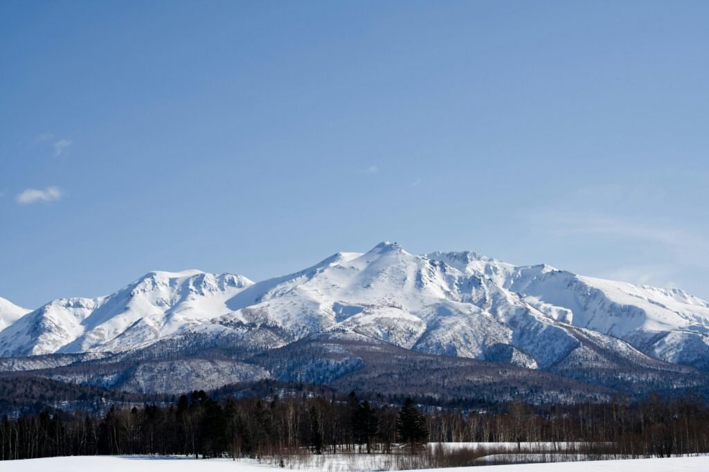 Majestic snowcapped mountains in Hokkaido under a clear blue sky, perfect for travel inspiration.